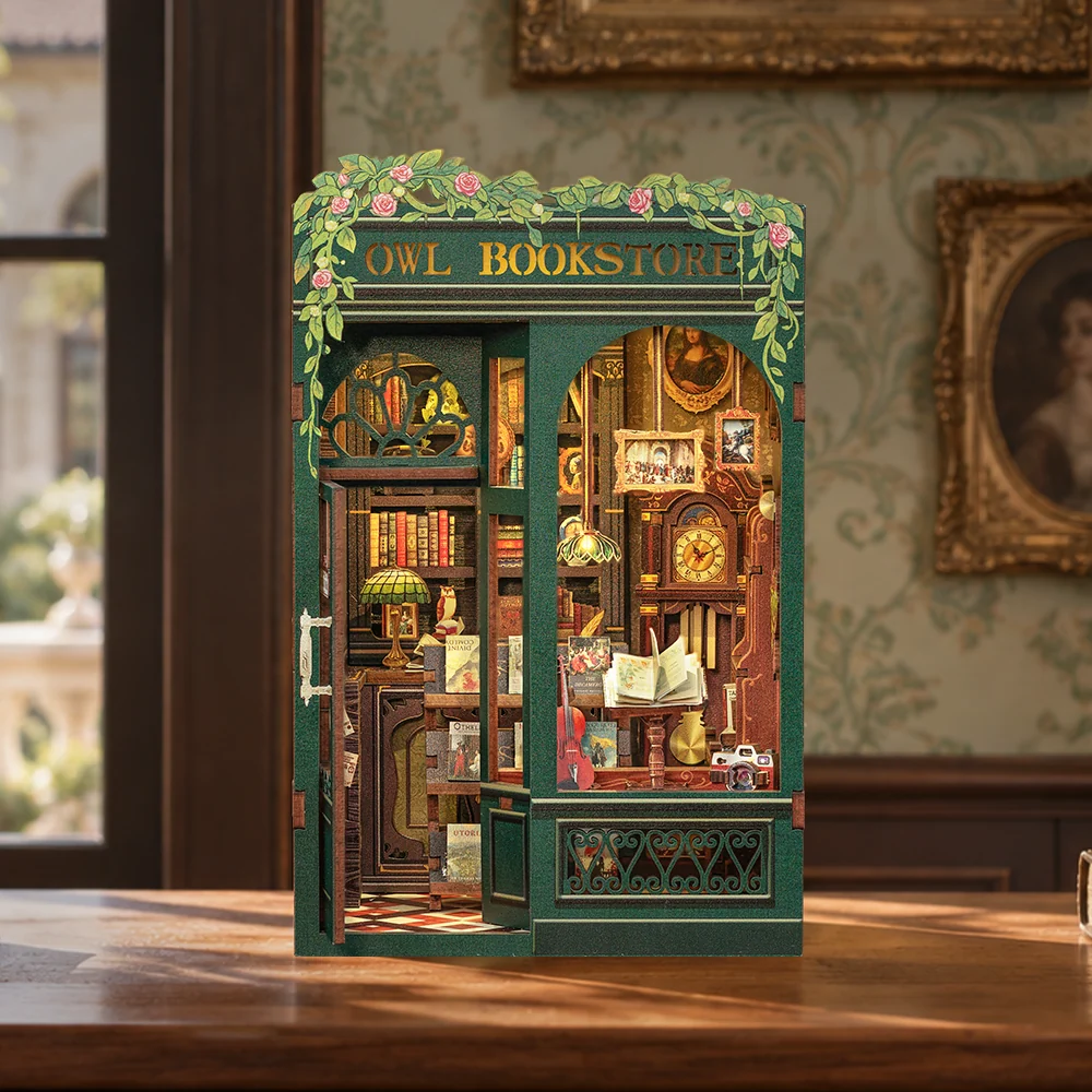CUTEBEE Owl Bookstore book nook kit with green storefront and lit miniature bookshop interior on a wooden table
