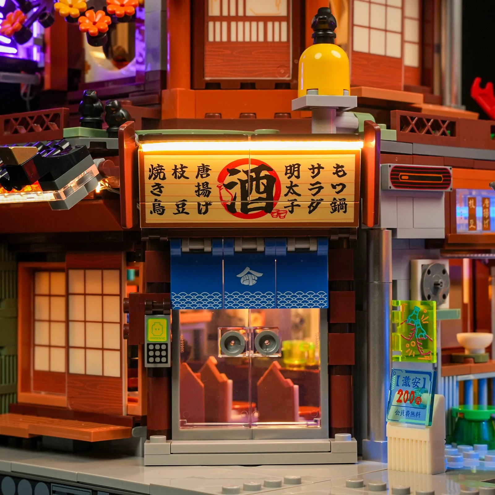 Close-up of the izakaya storefront with a lit Japanese sign and noren curtain