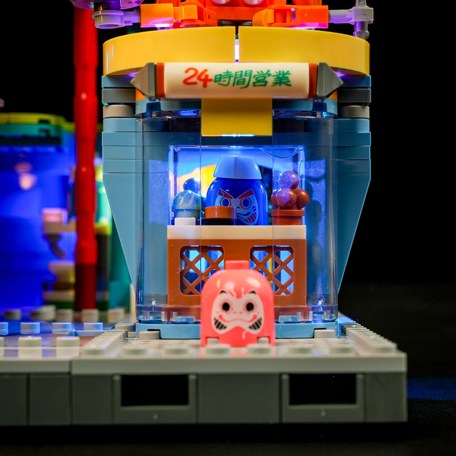 Close-up of the lit squid grill stand with a daruma figure